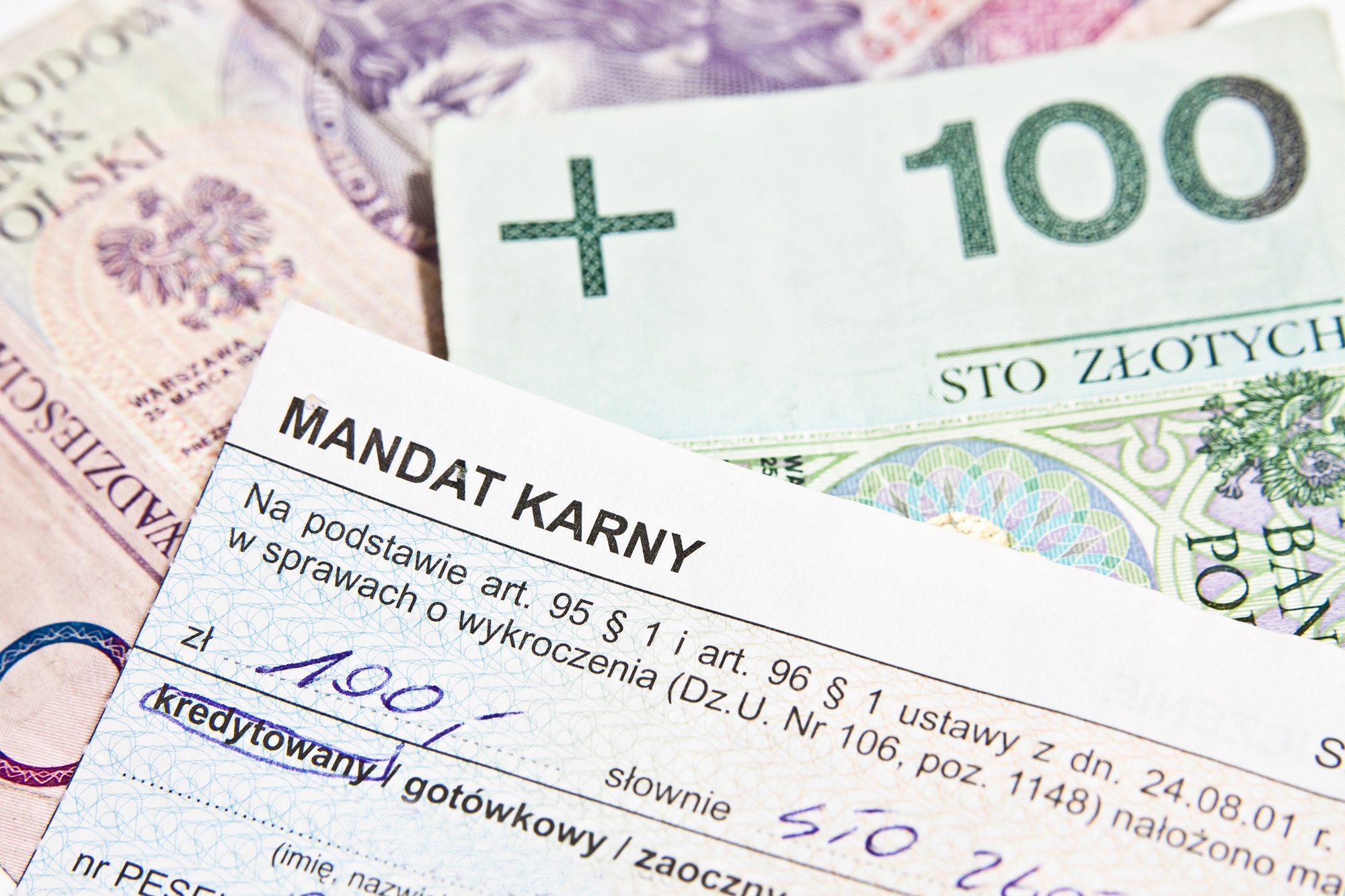 Mandat karny wystawiony na kwotę 100 zł. Mandat leżący na polskich banknotach