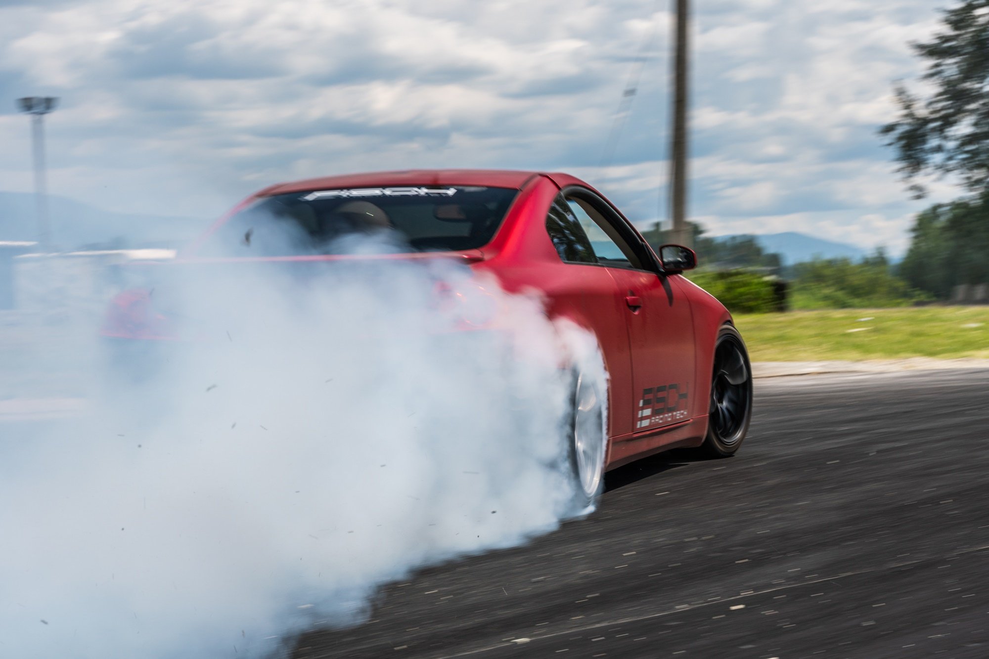 Czerwone auto driftujące na torze wyścigowym