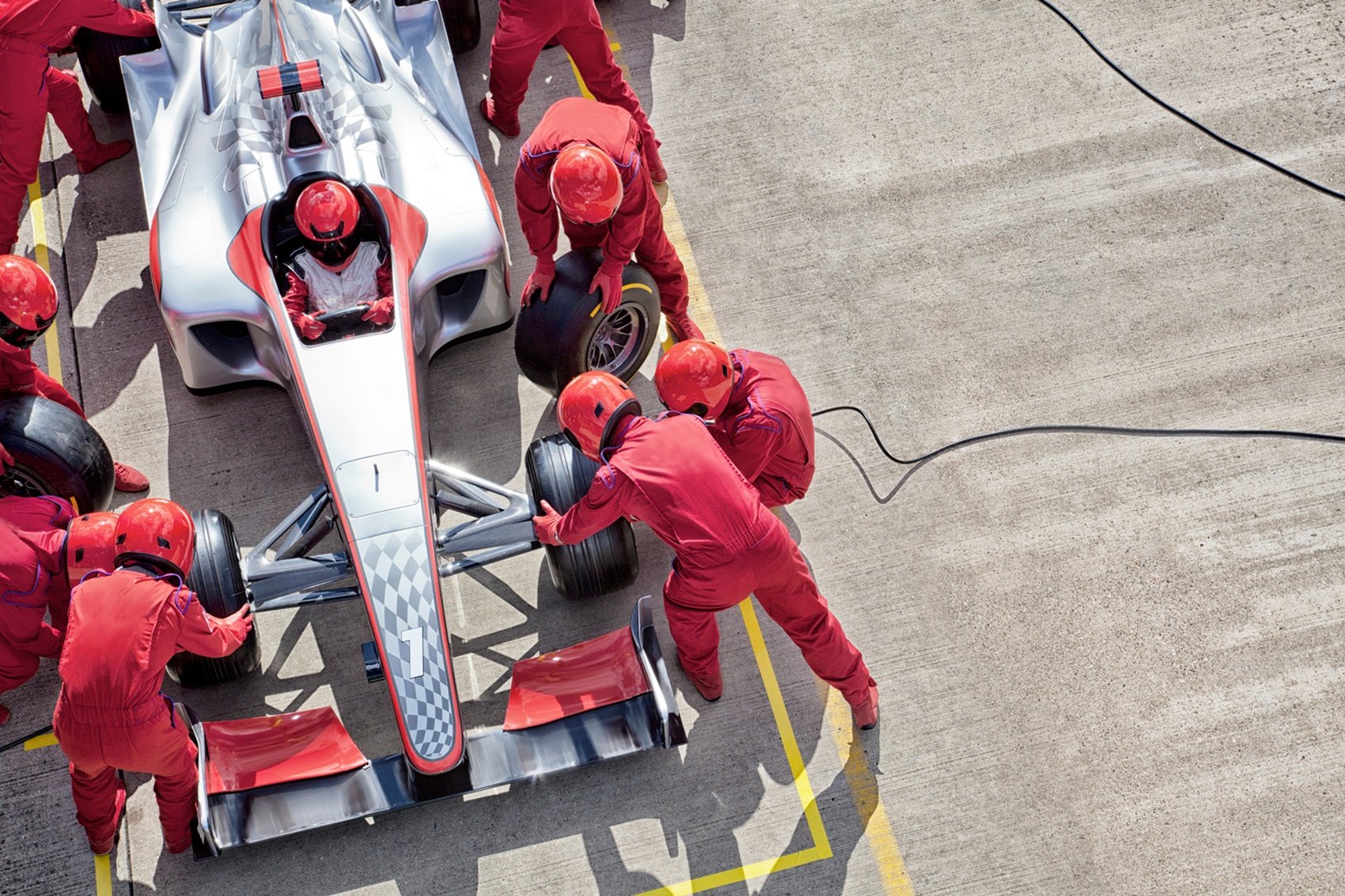 Mechnicy F1 zmieniający opony w pit stopie F1