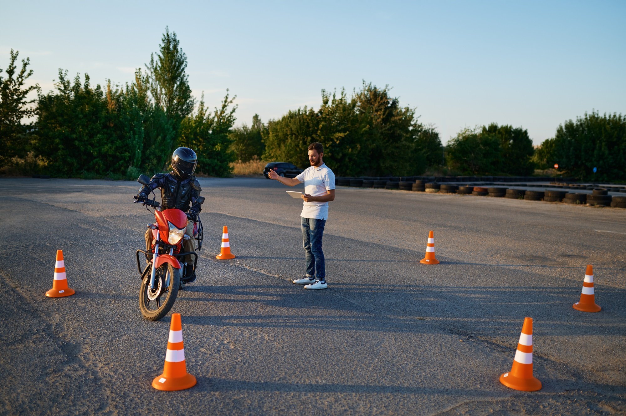Nauka jazdy na motocyklu. Kursant i instruktor na placu do nauki jazdy