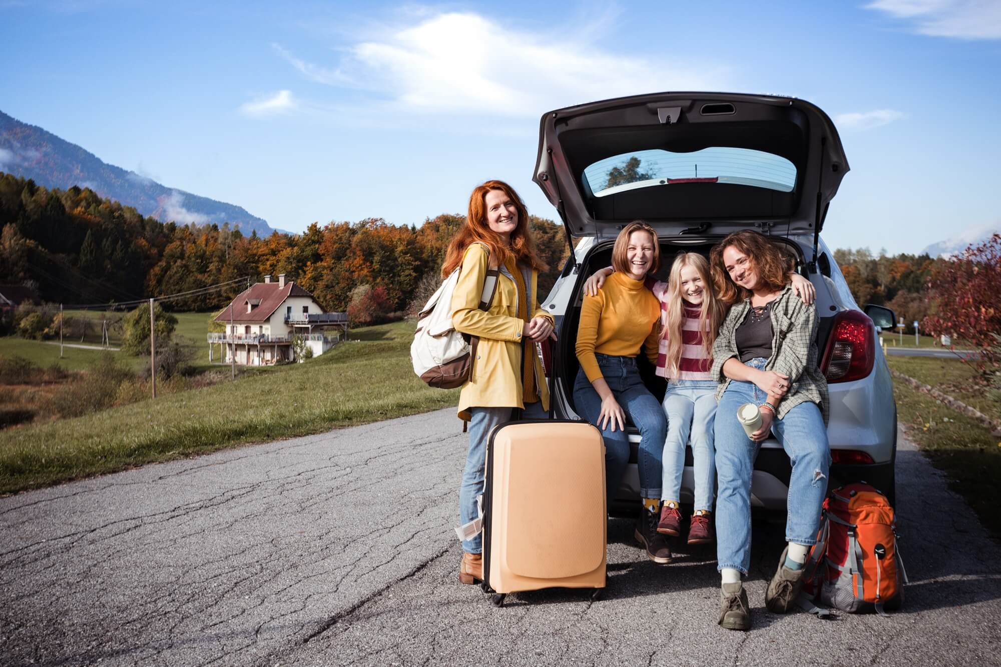 cztery kobiety przy aucie hatchback na tle gór